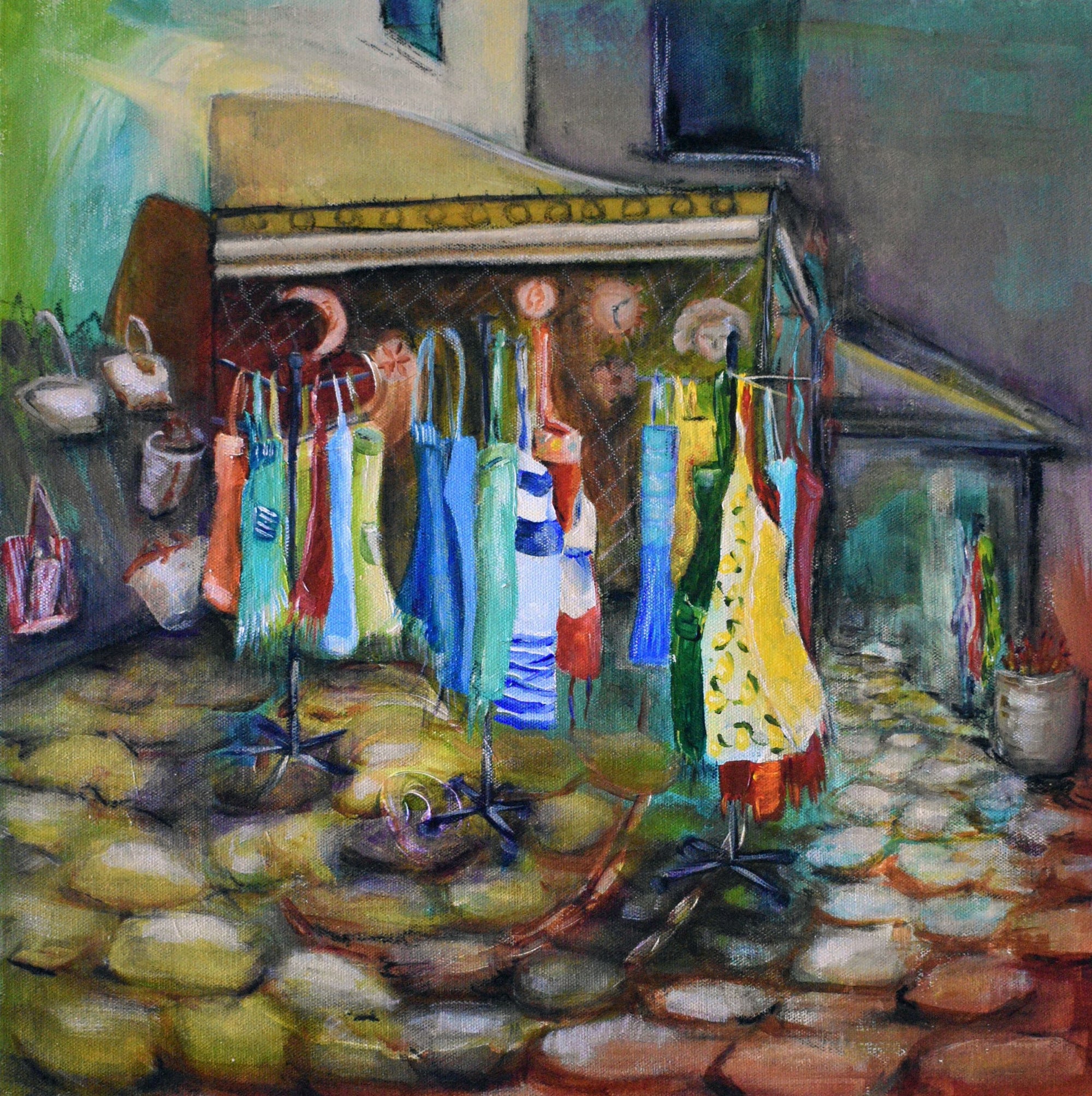 Bright colourful aprons on a market stall in a town in Cinque Terre, Italy hanging on a wall by Artist Jenni Rogers
